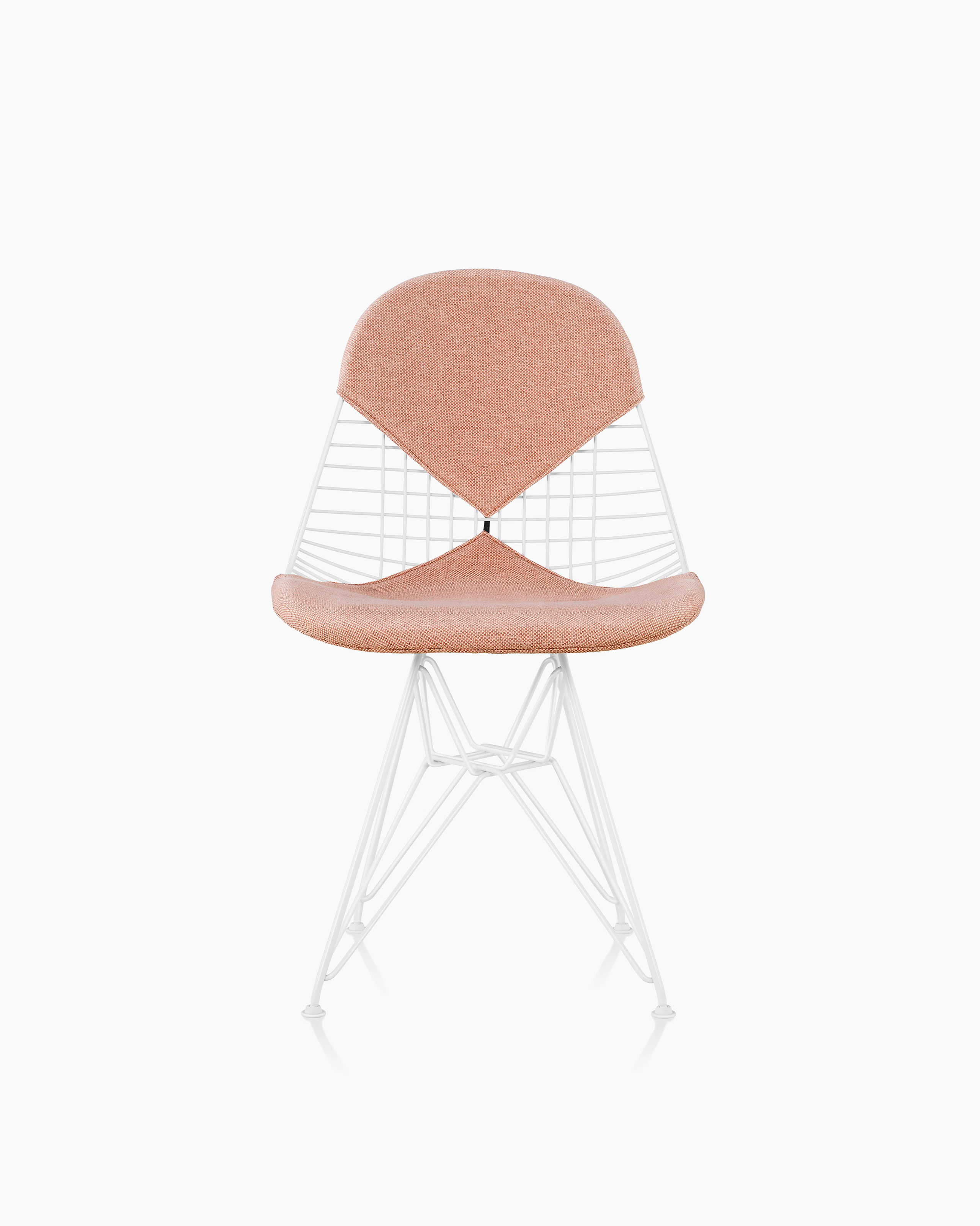 An Eames Wire Chair with a bikini seat and back, upholstered in a light pink textile. Viewed from the front.