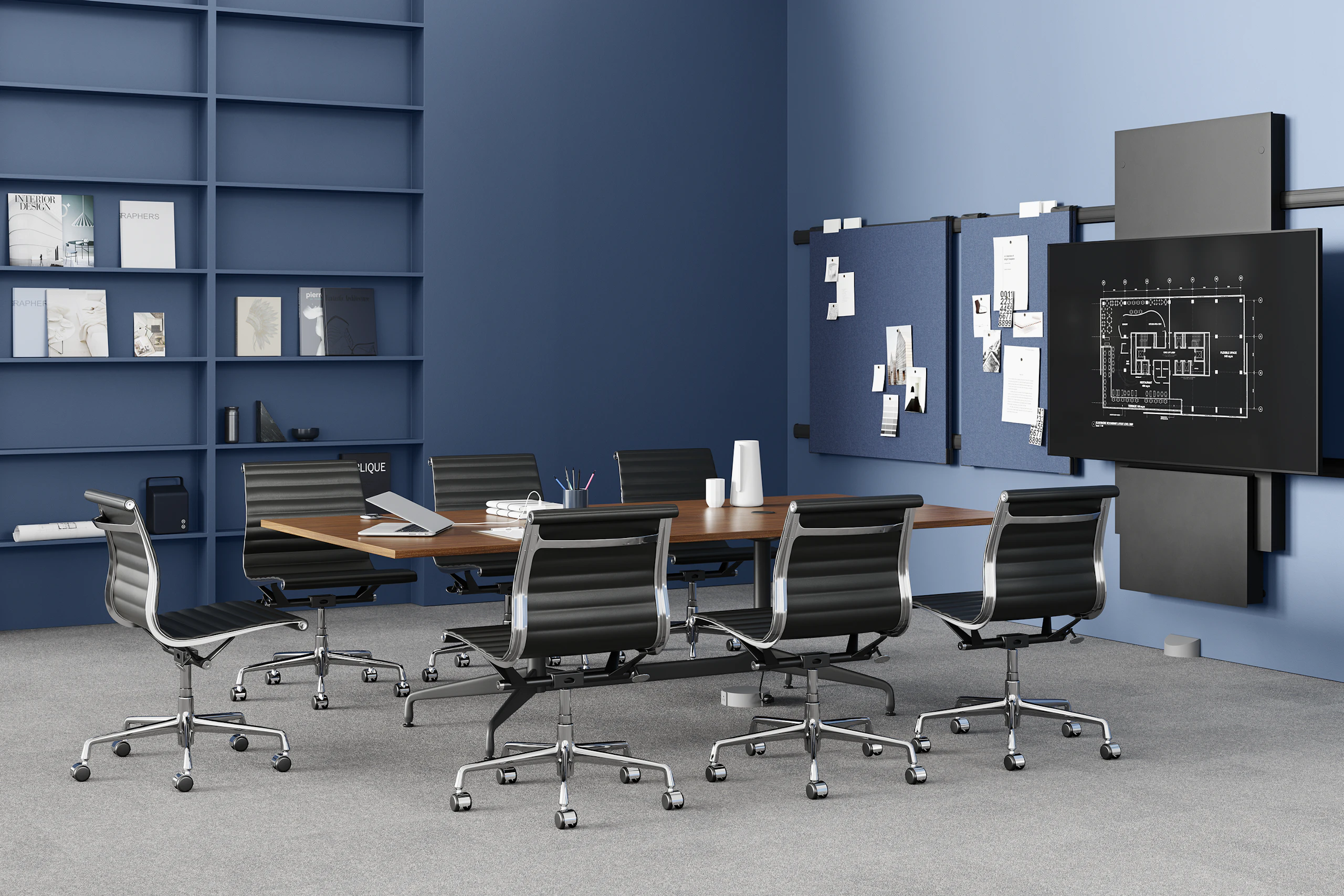 A conference table, surrounded by seven black Eames Aluminum Group chairs, is positioned in front of a large monitor. The table is powered by a Logic Reach wall start.