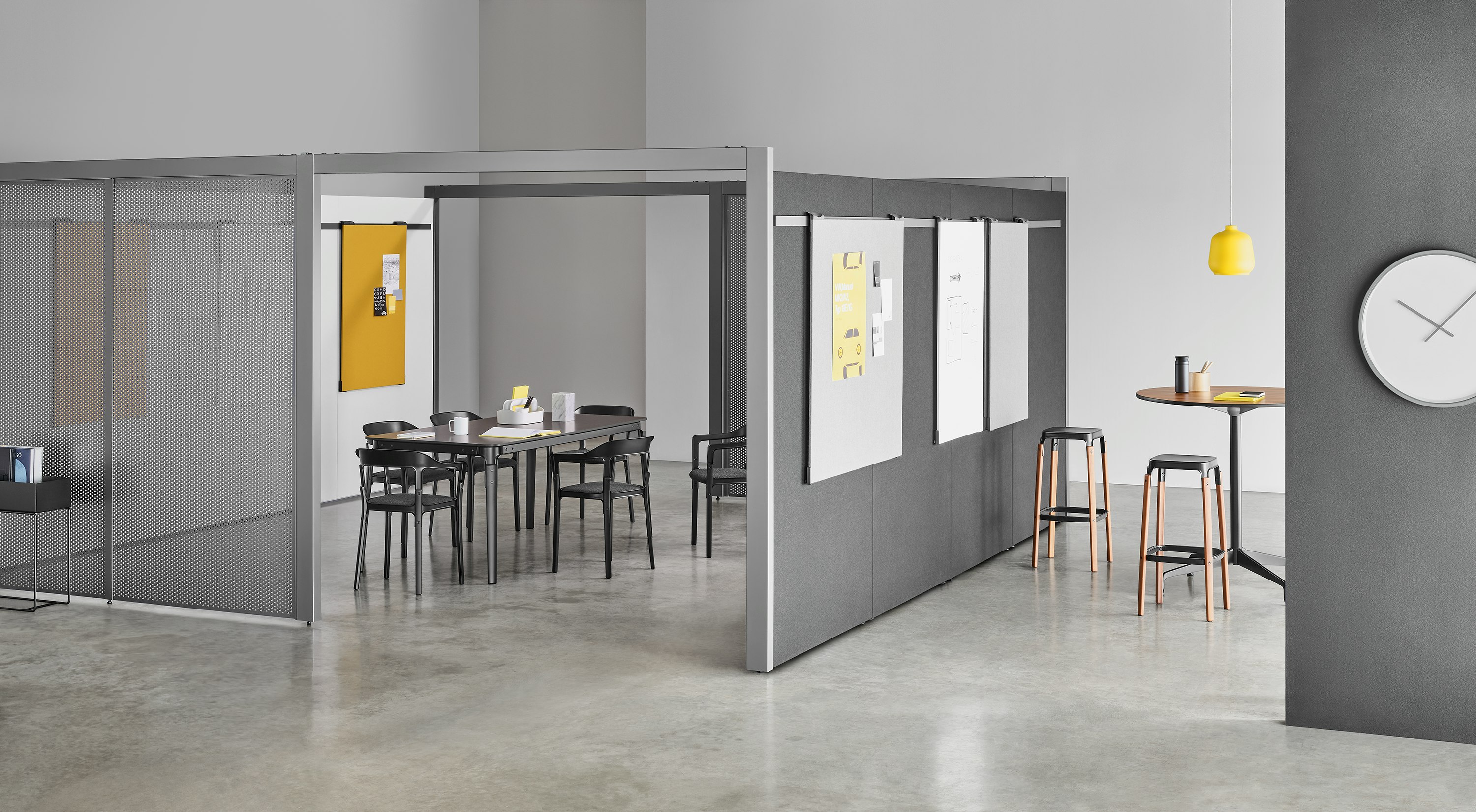A semi-enclosed Overlay room with two entryways, gray perforated metal exteriors, and markerboard interiors with a table and six chairs inside.