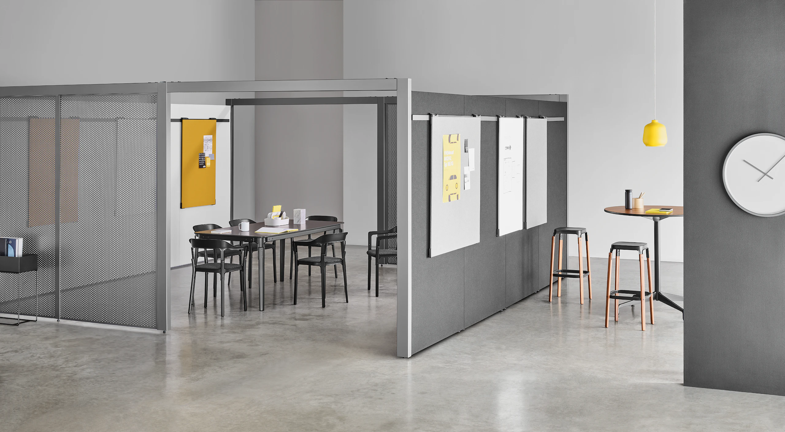A semi-enclosed Overlay room with two entryways, gray perforated metal exteriors, and markerboard interiors with a table and six chairs inside.