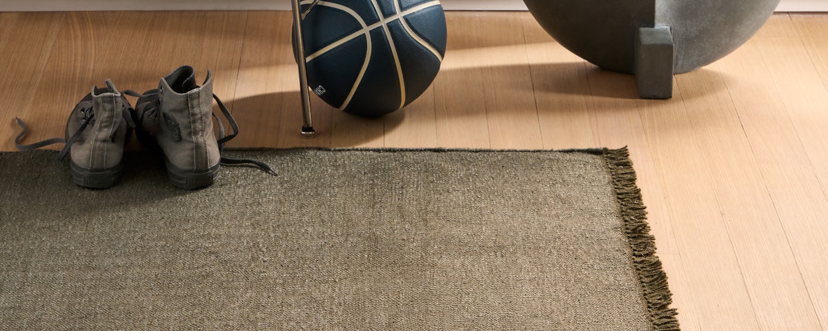 Pallo Flatweave Linen Rug at home entryway with sneakers and basketball