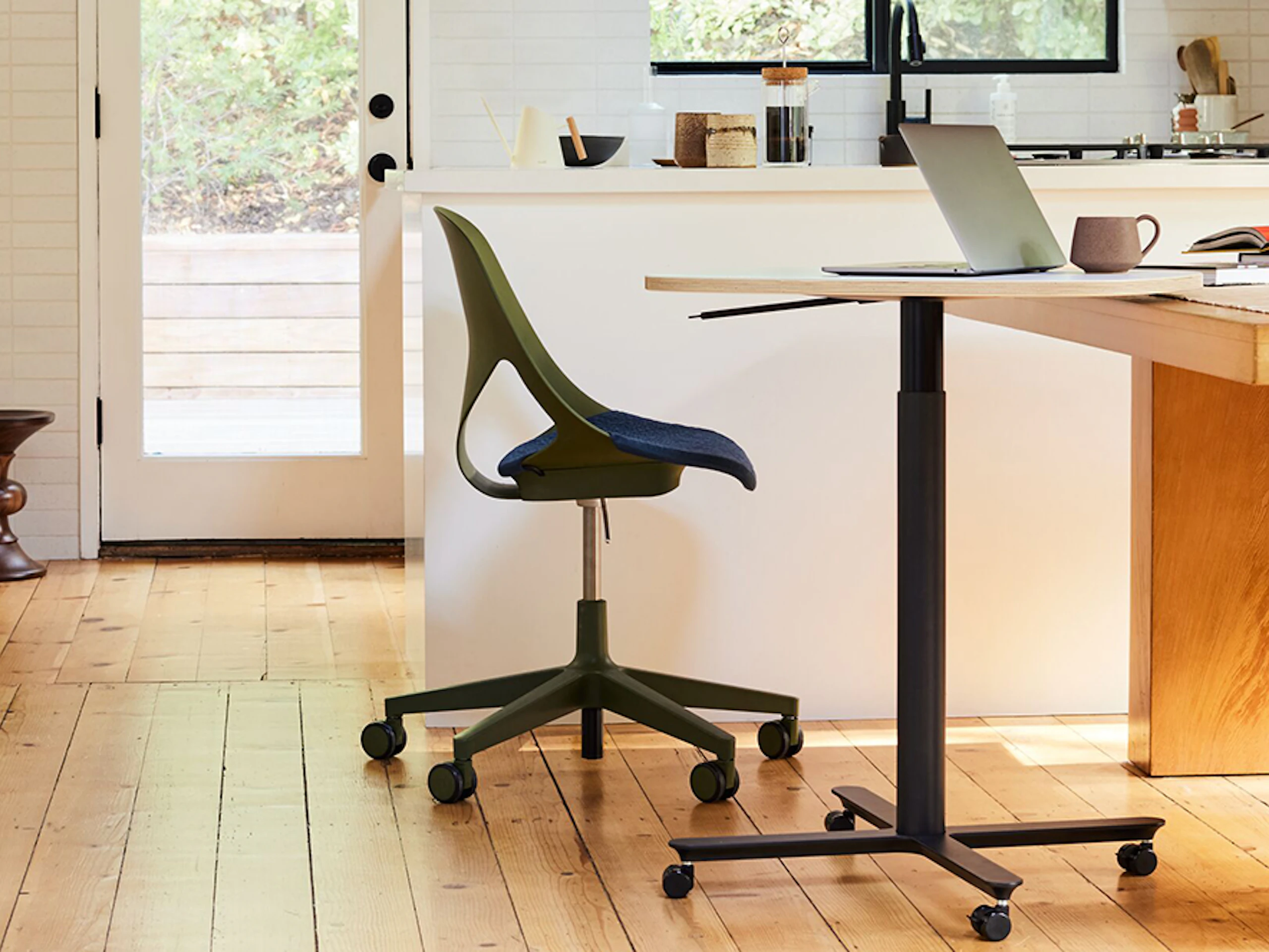 An olive colored Zeph Chair with a large Passport Work Table in a home kitchen setting.