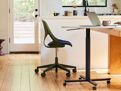 An olive colored Zeph Chair with a large Passport Work Table in a home kitchen setting.