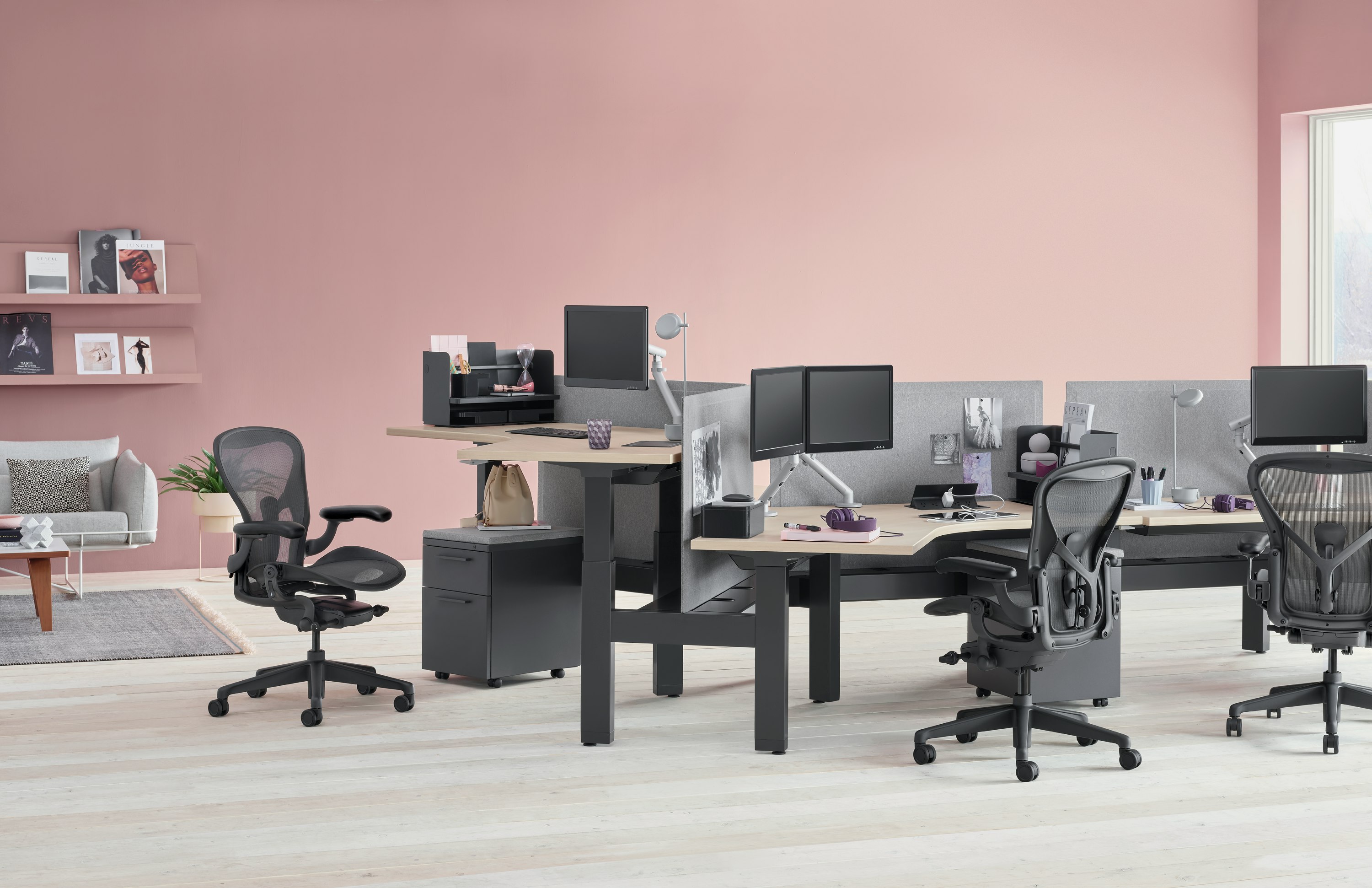 Standing desk system, Renew Link, with 120-degree work surfaces, Tu pedestals, and Aeron chairs. One of the six desks is raised at a standing height.