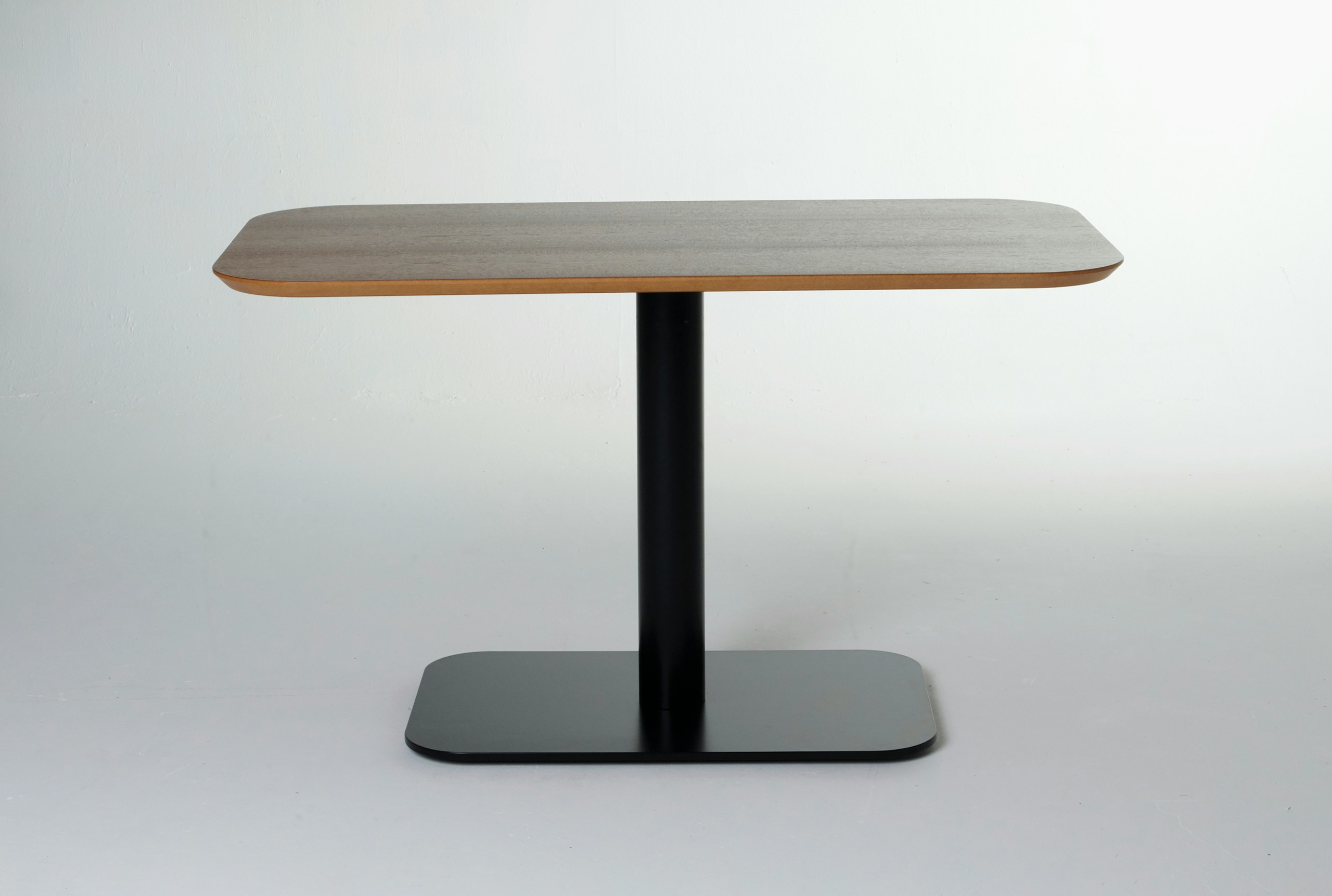 White sweep shot of Hue table with black metal base and walnut veneer table top, viewed from the front.