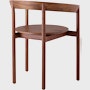 A walnut Comma Chair with arms, viewed from the back at an angle.