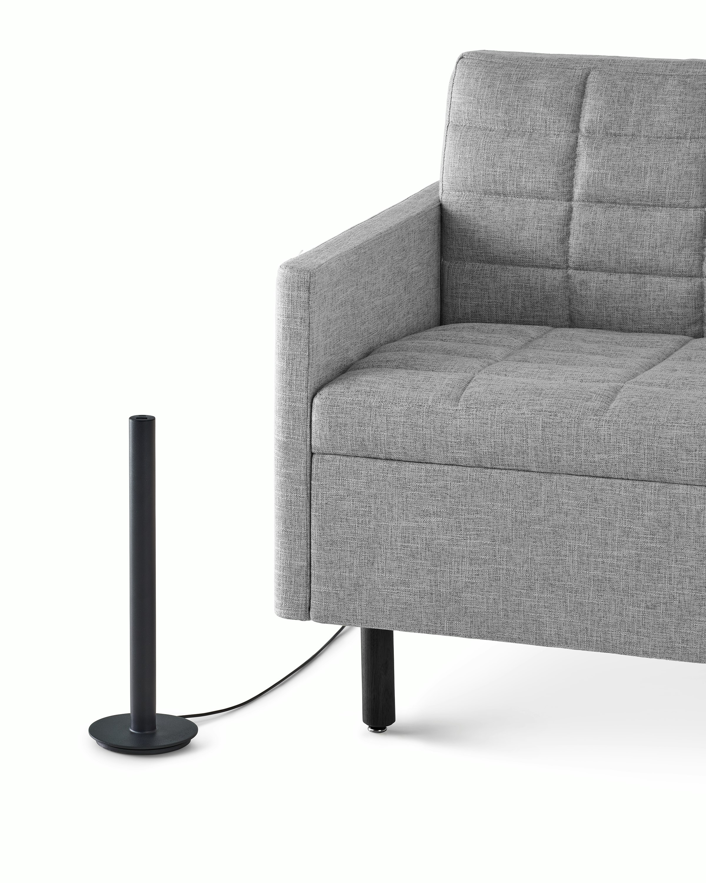 A black Logic Micro Tower beside a gray Tuxedo Lounge Chair.