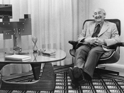 Herman Miller founder D.J. De Pree reclines in an Eames Lounge Chair next to a glass-top Noguchi Table.