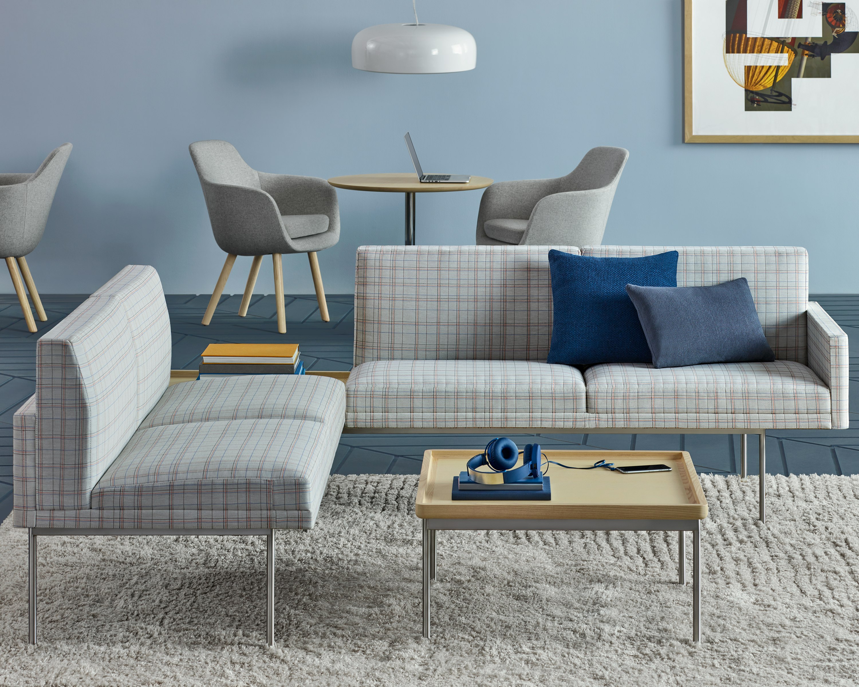 A lounge featuring Saiba Side Chairs in the background and Tuxedo Component settees with a Tuxedo Component coffee table in the foreground.