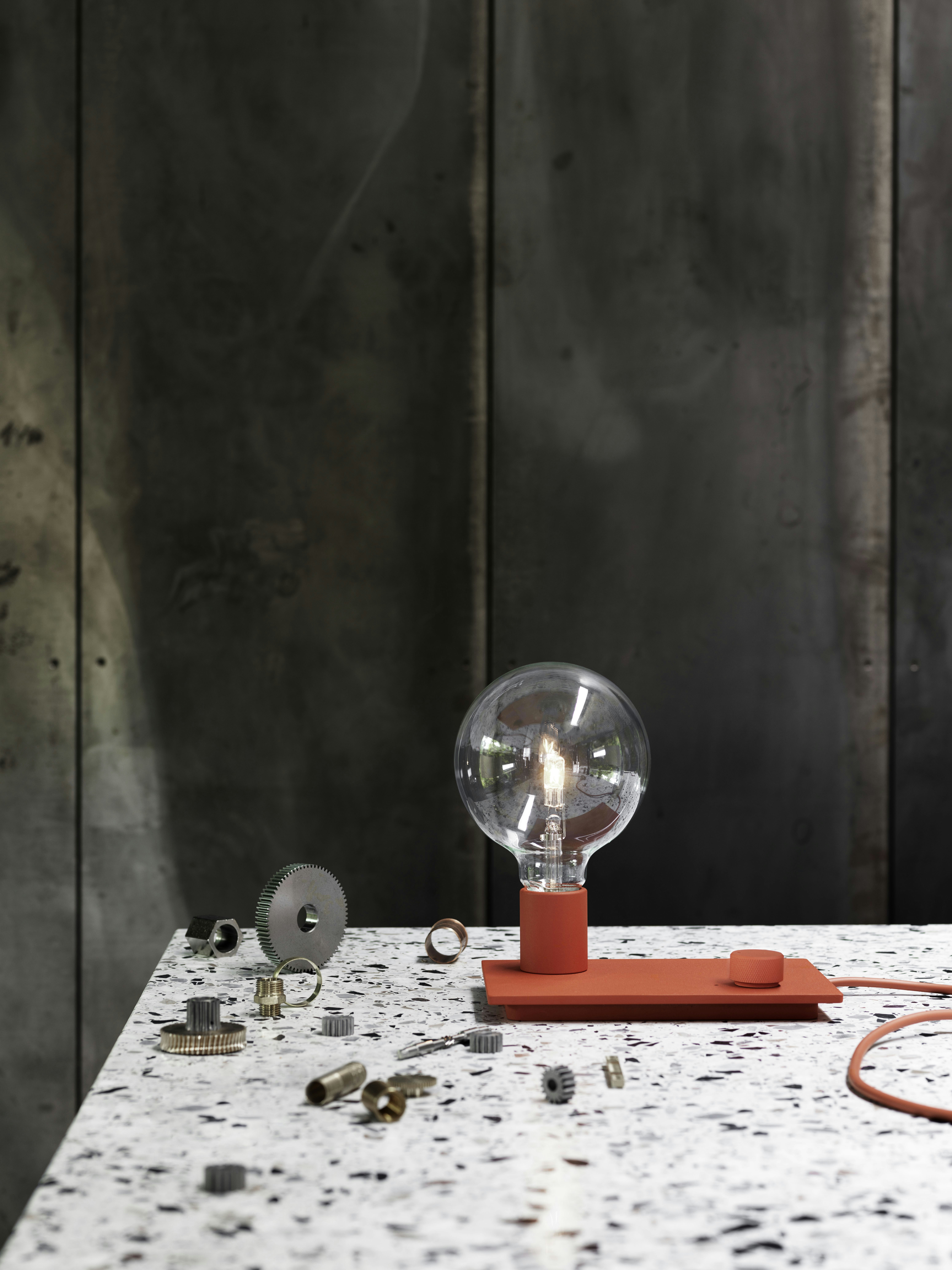Control Table Lamp on a countertop surrounded by assorted mechanical parts