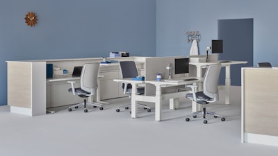A caregiver team environment with a white and wood laminate prefab Commend Nurses Station, Verus Chairs, Renew Link, and Renew Sit-to-Stand Tables.