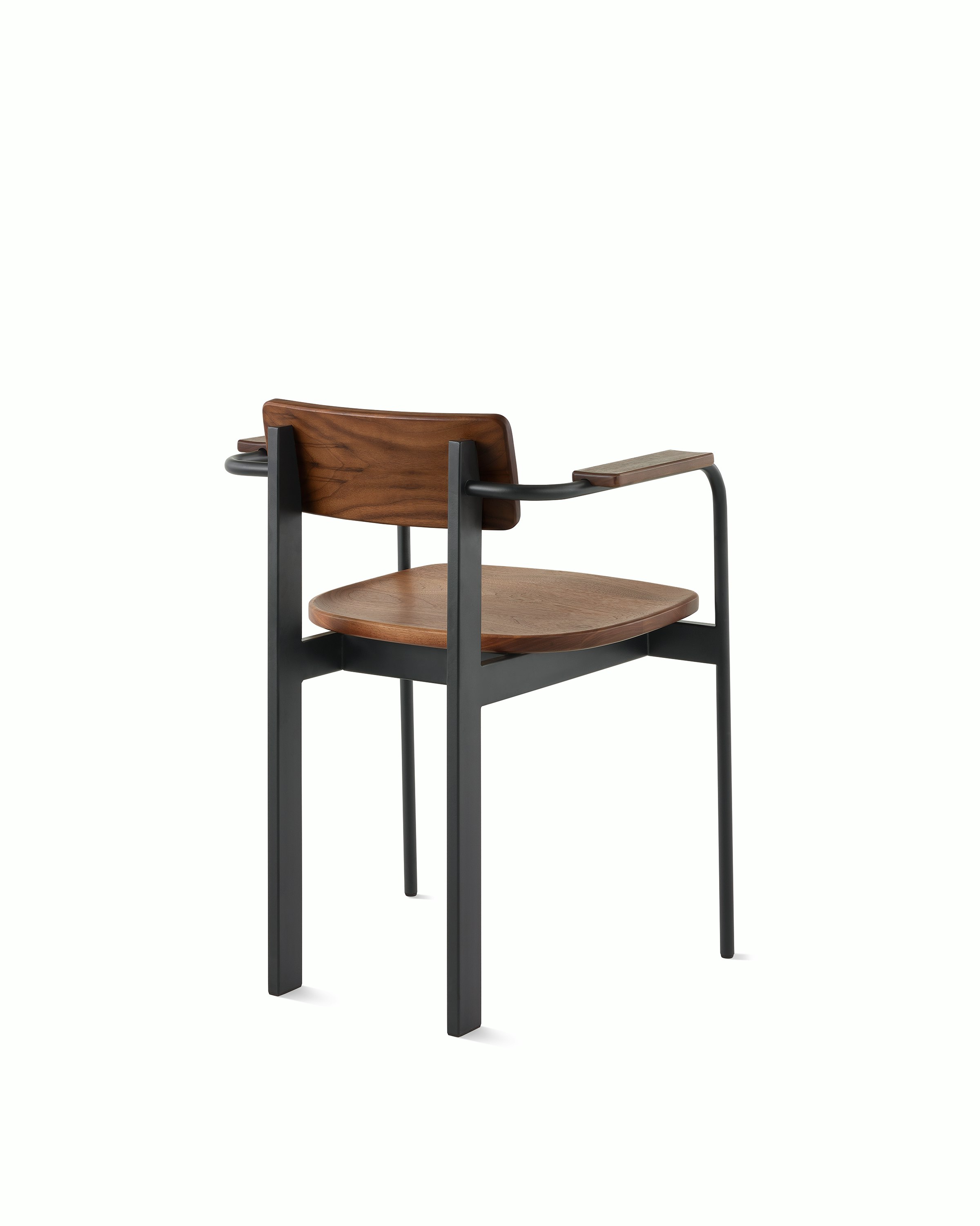 A Betwixt Chair with a walnut backrest, seat, and arms with a black frame.