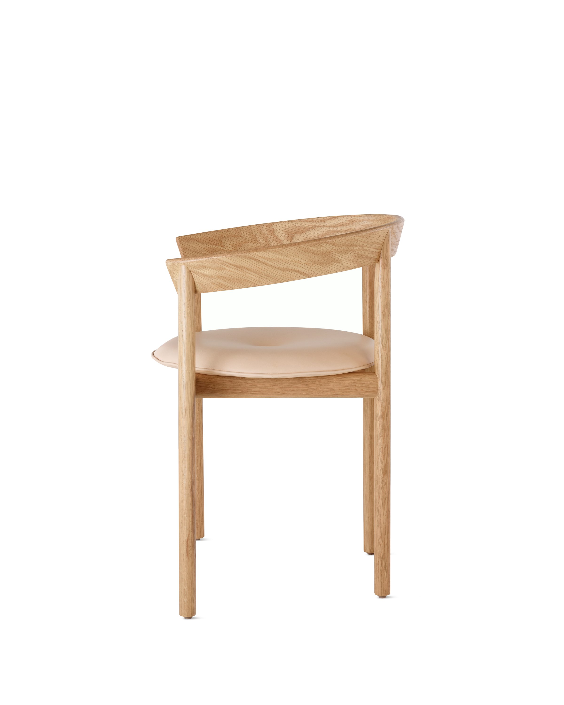 Profile view of an oak Comma Chair with arms and a seat pad.