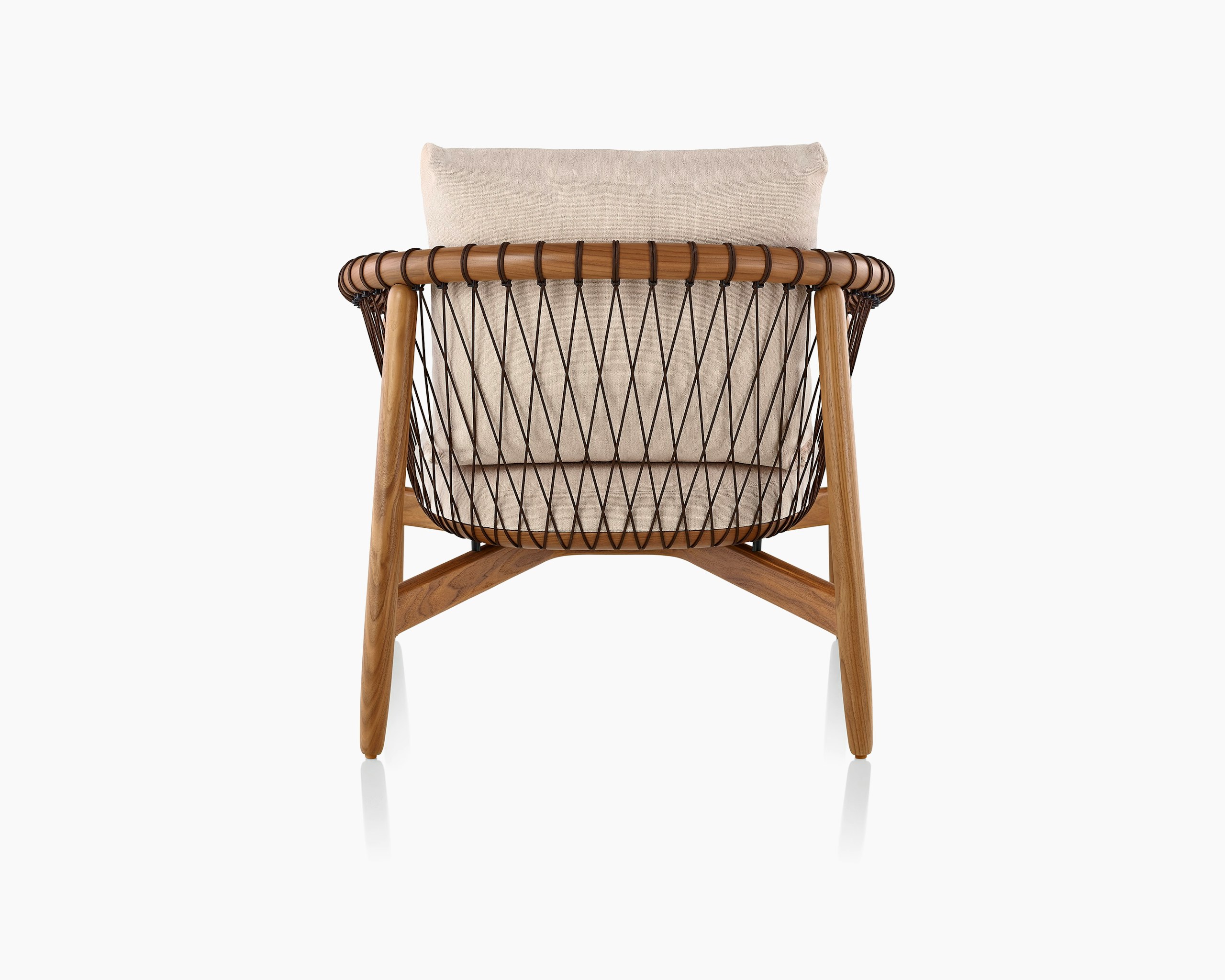A Crosshatch lounge chair with linen-colored fabric and a wood frame in a medium finish, viewed from behind.