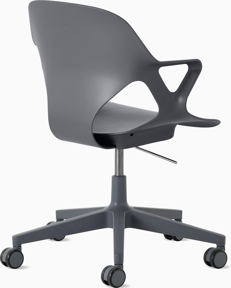 Rear angle view of a Zeph chair with fixed arms in dark grey.