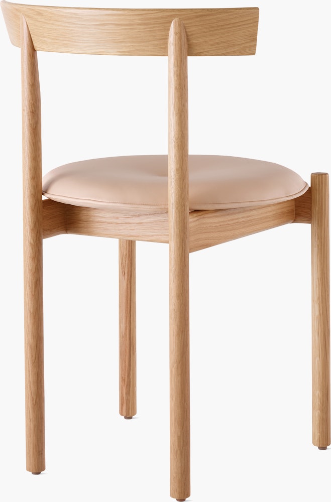 An oak Comma Chair with a seat pad, viewed from the back at an angle.