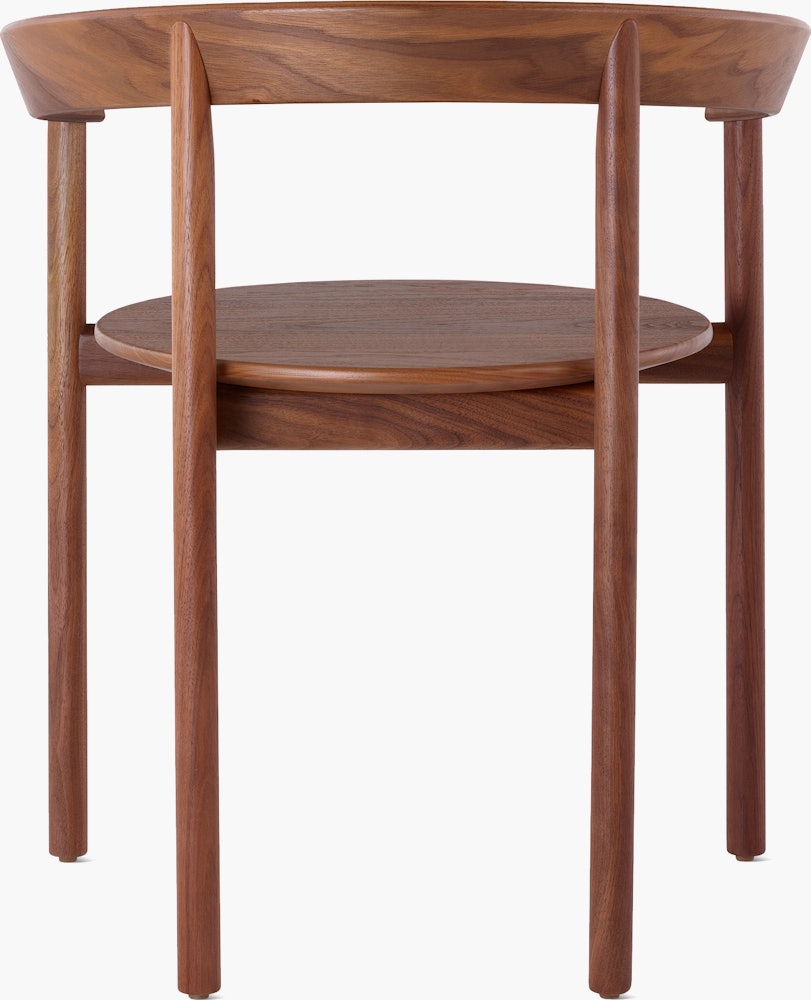 A walnut Comma Chair with arms, viewed from the back.