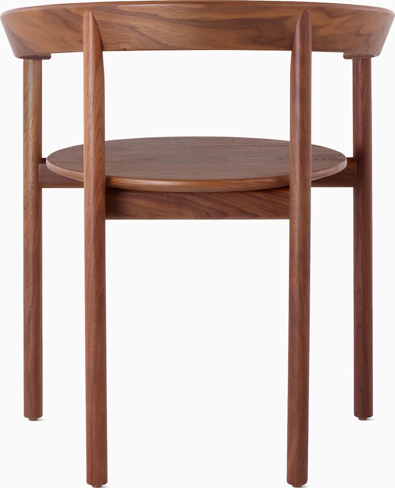 A walnut Comma Chair with arms, viewed from the back.