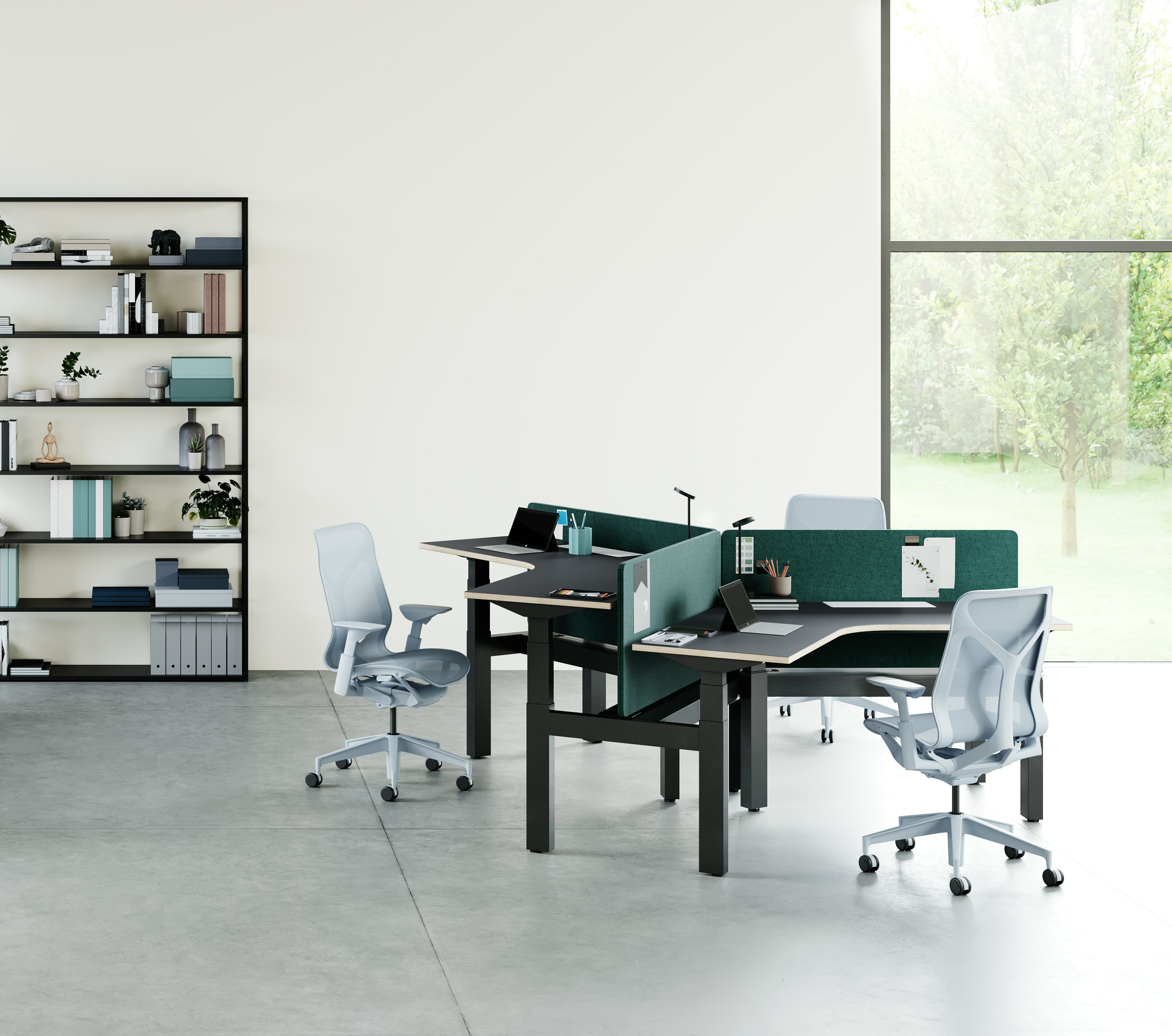 An open office environment with a cluster of 3 Ratio 120 desks positioned at varying heights. Cosm Chairs with height adjustable arms are positioned around the desks.