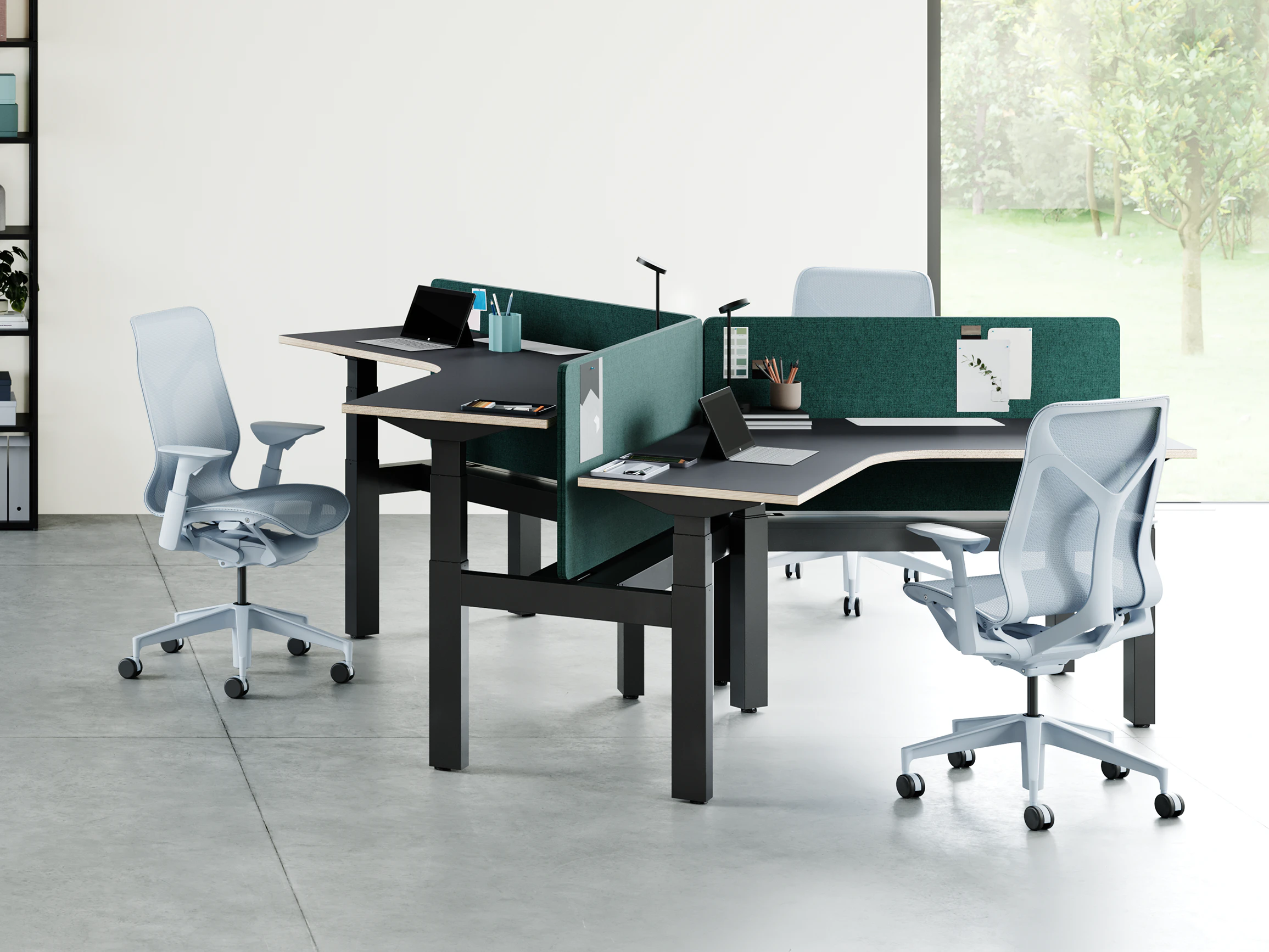 An open office environment with a cluster of 3 Ratio 120 desks positioned at varying heights. Cosm Chairs with height adjustable arms are positioned around the desks.