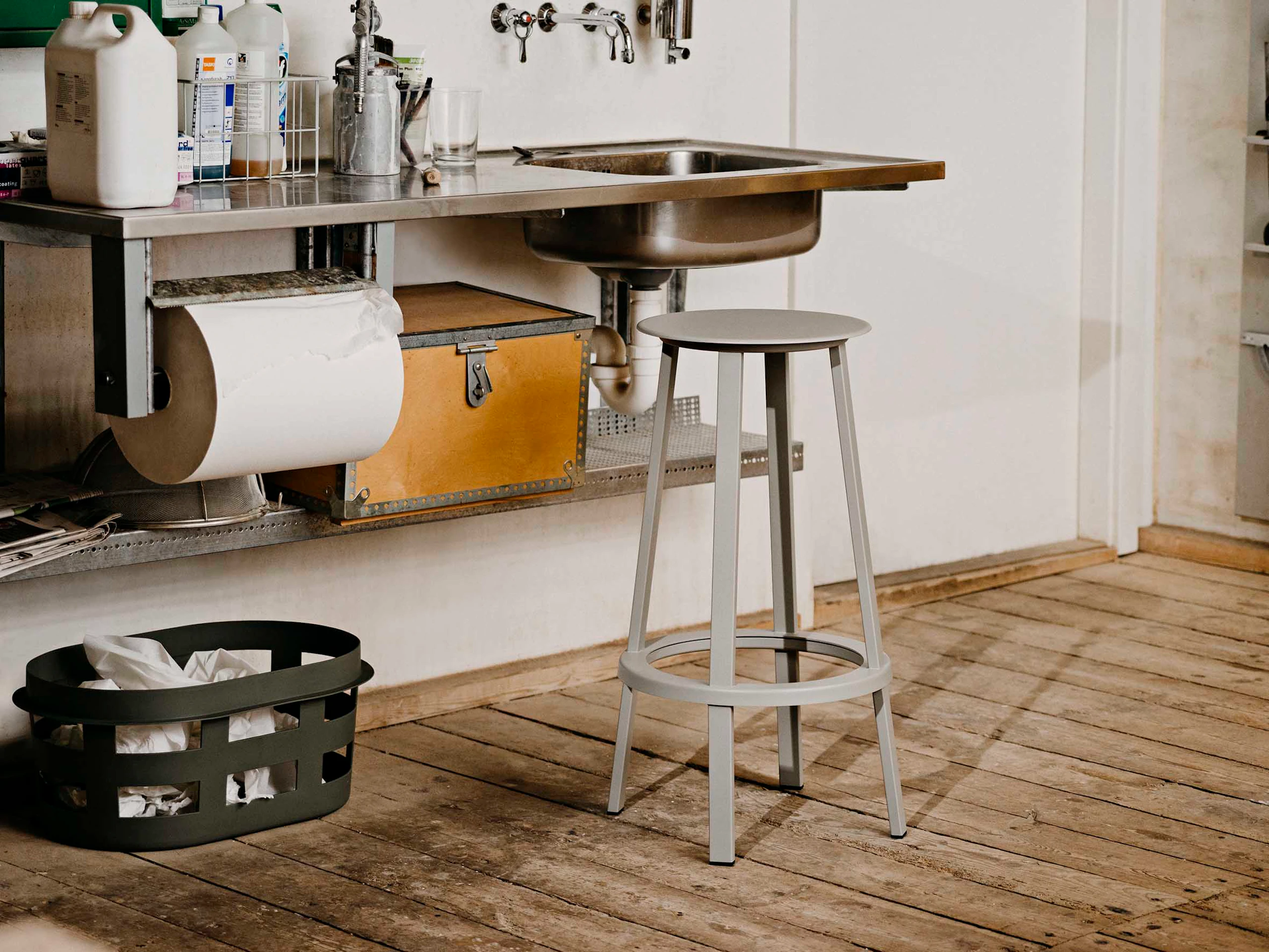 Grey Revolver Stool placed in front of a sink in a work room.