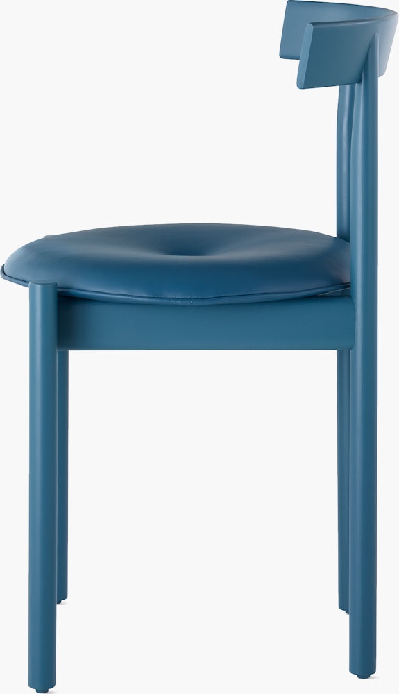 Profile view of a blue Comma Chair with a seat pad.