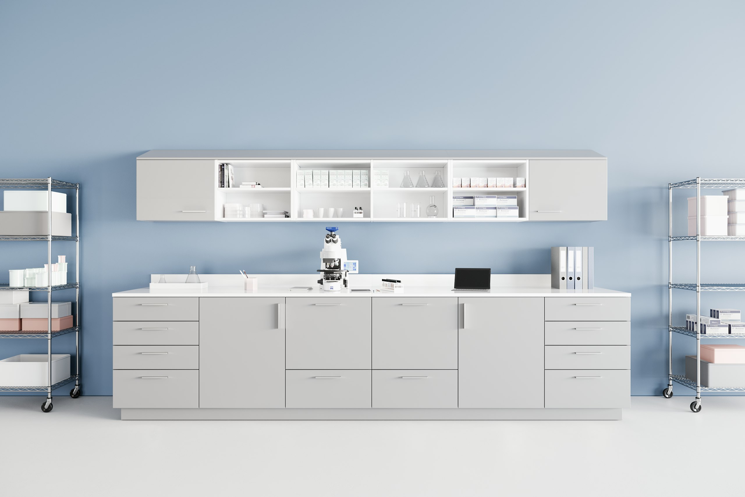 Mora casework with a sloped top in a laboratory environment in a folkstone gray laminate finish and a white solid surface top and Eagle open wire storage.