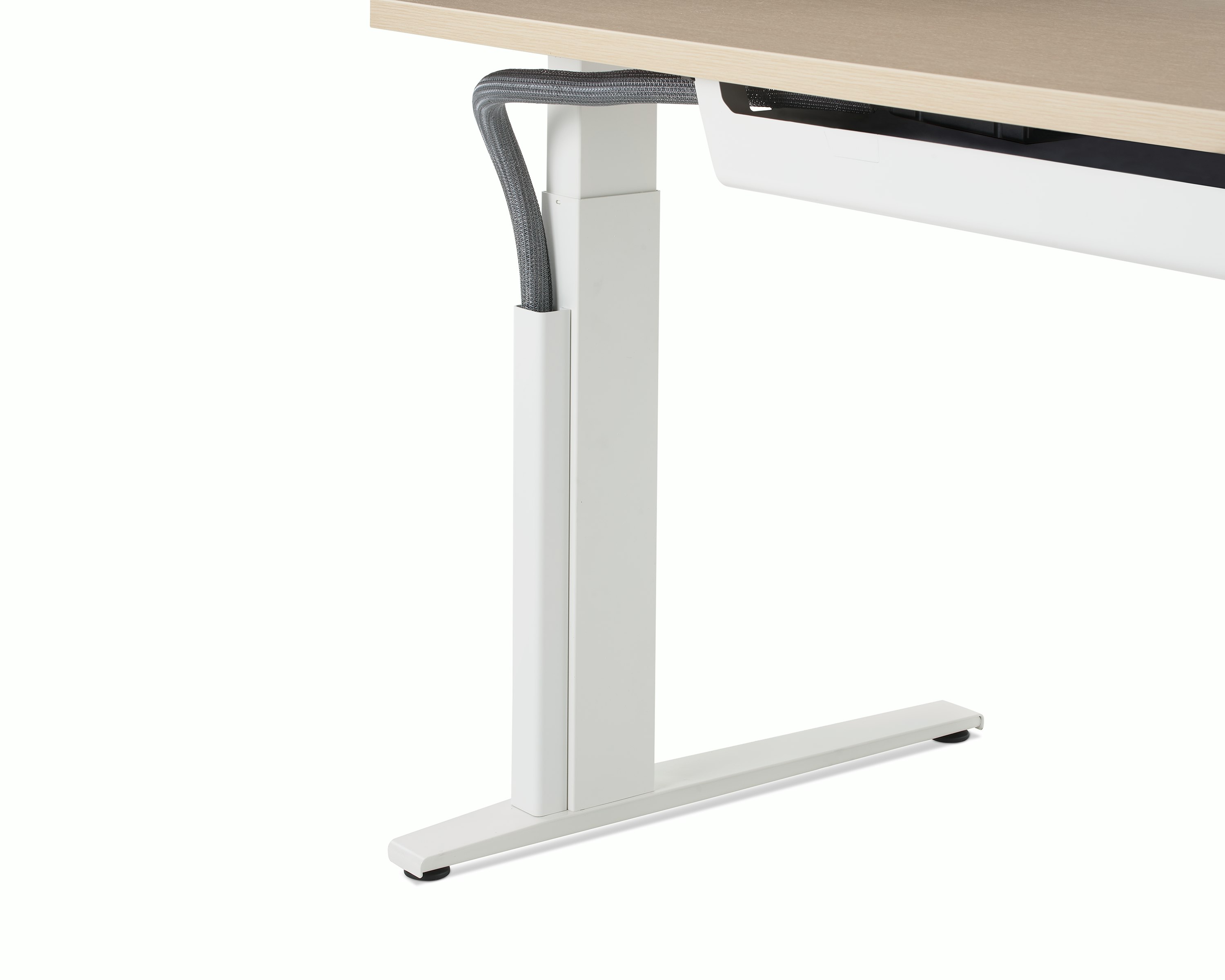 Close up of a mesh vertical wire manager attached to the white leg of a height adjustable table.