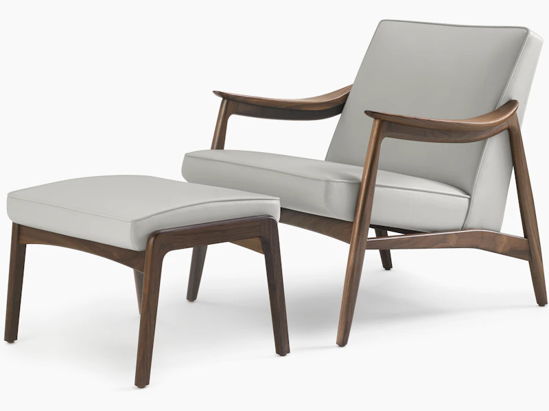 An Aspen Lounge Chair and Ottoman in a gray textile with walnut base and arms.