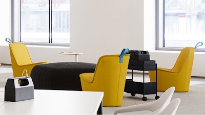 A communal seating area - furnished with yellow NaughtOne Pippin chairs and a Herman Miller OE1 Storage Trolley - used to encourage face-to-face interaction
