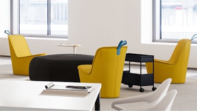 A communal seating area - furnished with yellow NaughtOne Pippin chairs and a Herman Miller OE1 Storage Trolley - used to encourage face-to-face interaction