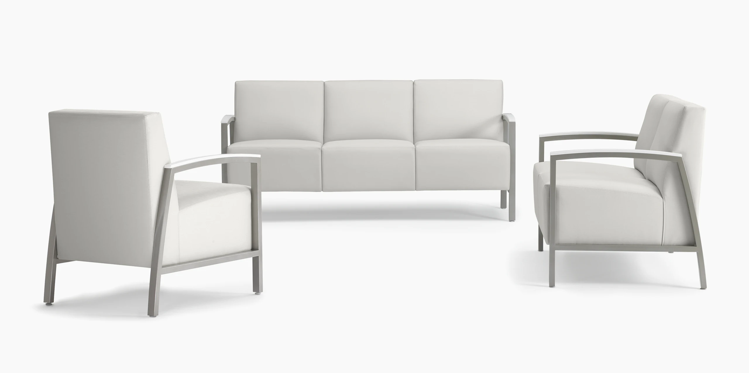 A trio of Brava Modern Lounge Seating consisting of one chair, a two seat, and three seat, all with solid surface arm caps.