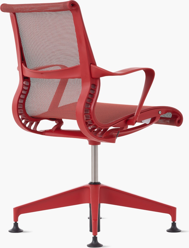 Rear angle view of a Setu side chair with fixed arms in red.