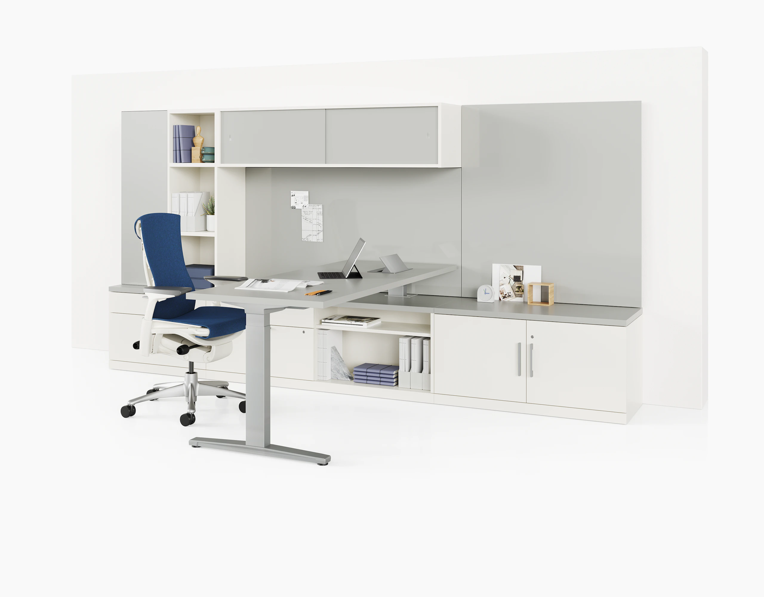 Grey and white Canvas Private Office with height adjustable table, storage, and blue Embody Chair.