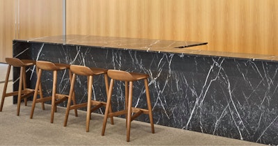 Four brown counter-height stools at a dark grey and white counter