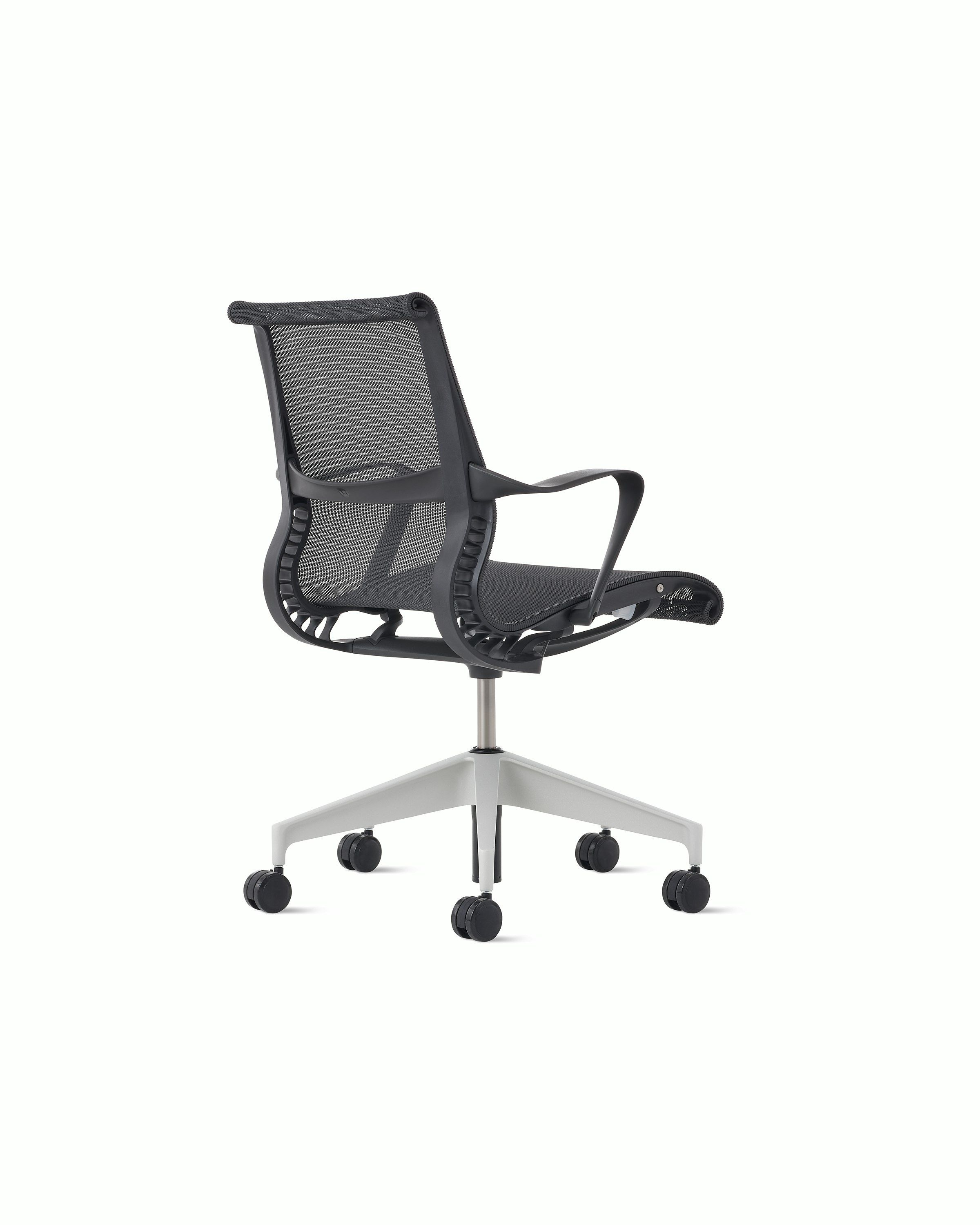 Rear angle view of a Setu chair in dark grey with a silver alloy base.