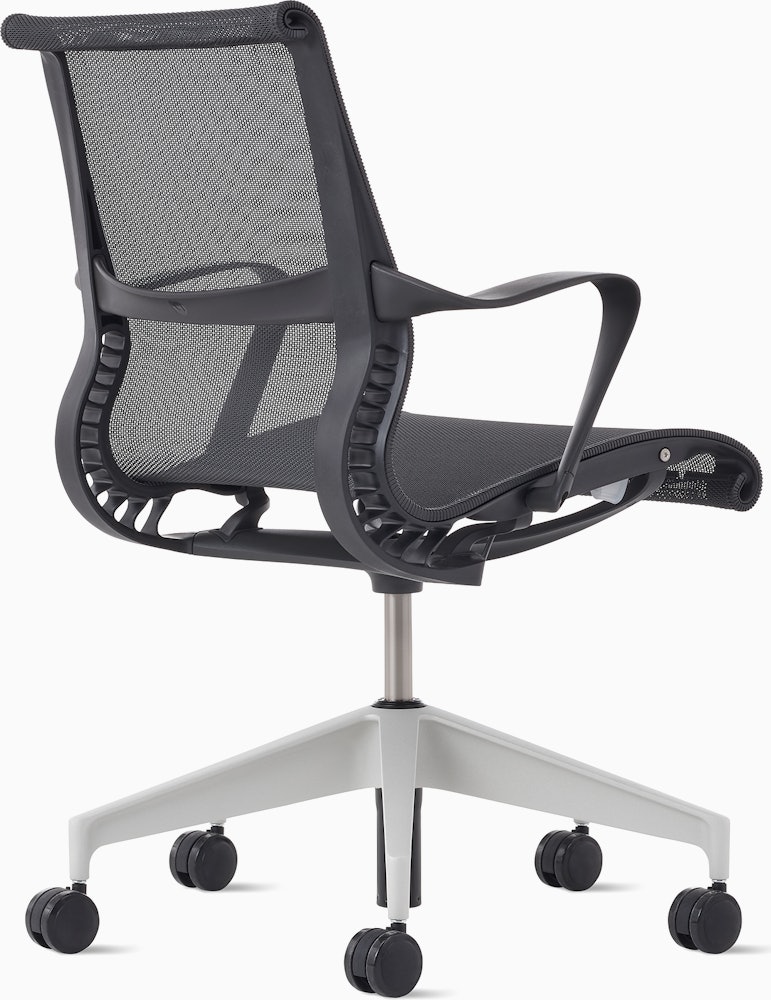 Rear angle view of a Setu chair in dark grey with a silver alloy base.