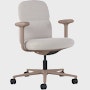 Front angle view of a mid-back Asari chair by Herman Miller in light brown with height adjustable arms.