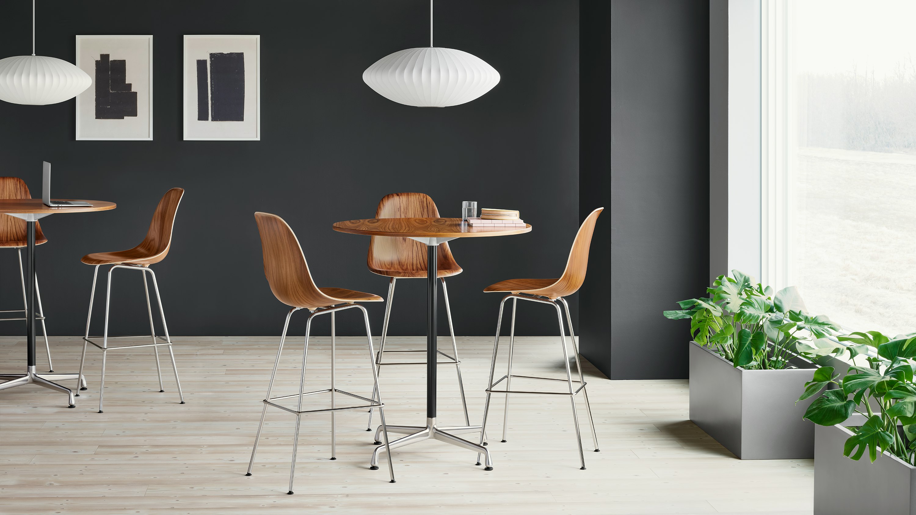 Three Eames Molded Wood Stools in santos palisander around an Eames standing height table with a santos palisander surface.