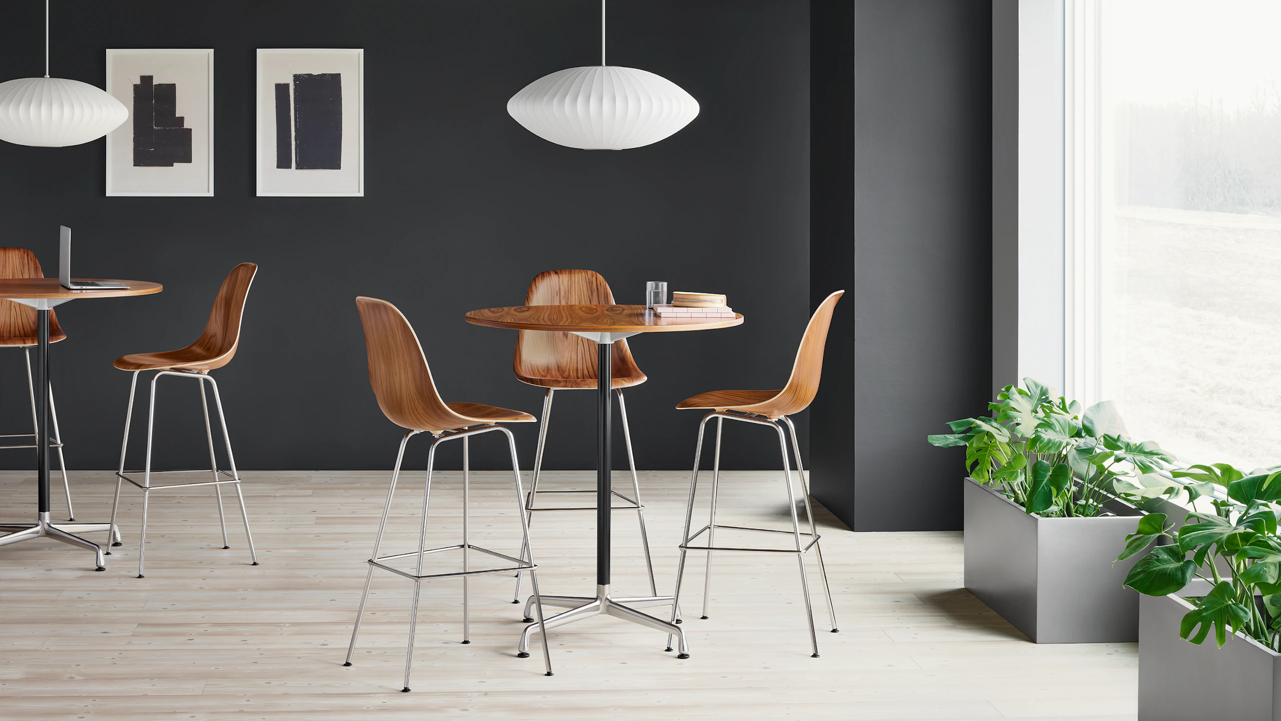 Three Eames Molded Wood Stools in santos palisander around an Eames standing height table with a santos palisander surface.