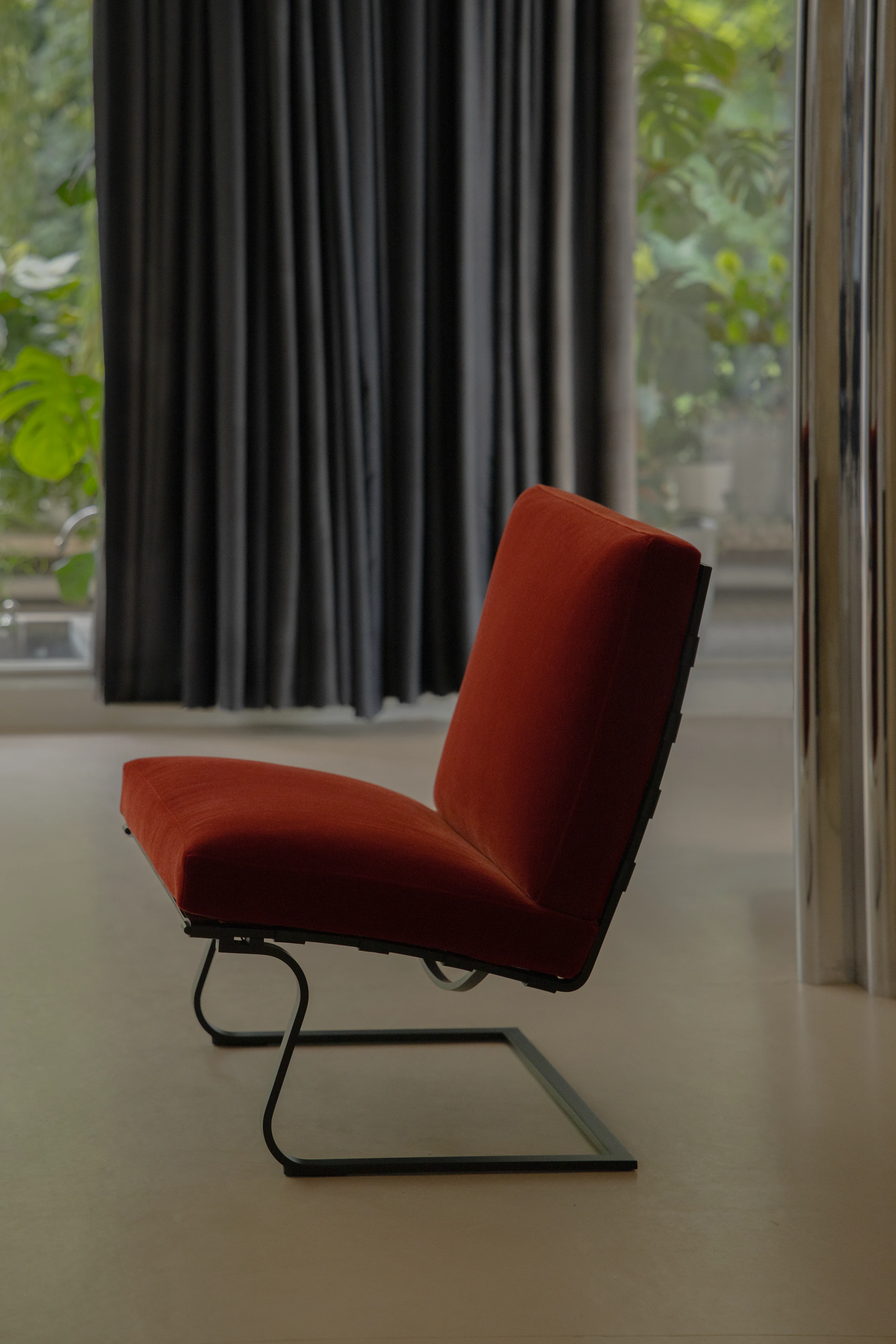 Tugendhat Chair in red velvet with a black base at Villa Tugendhat.