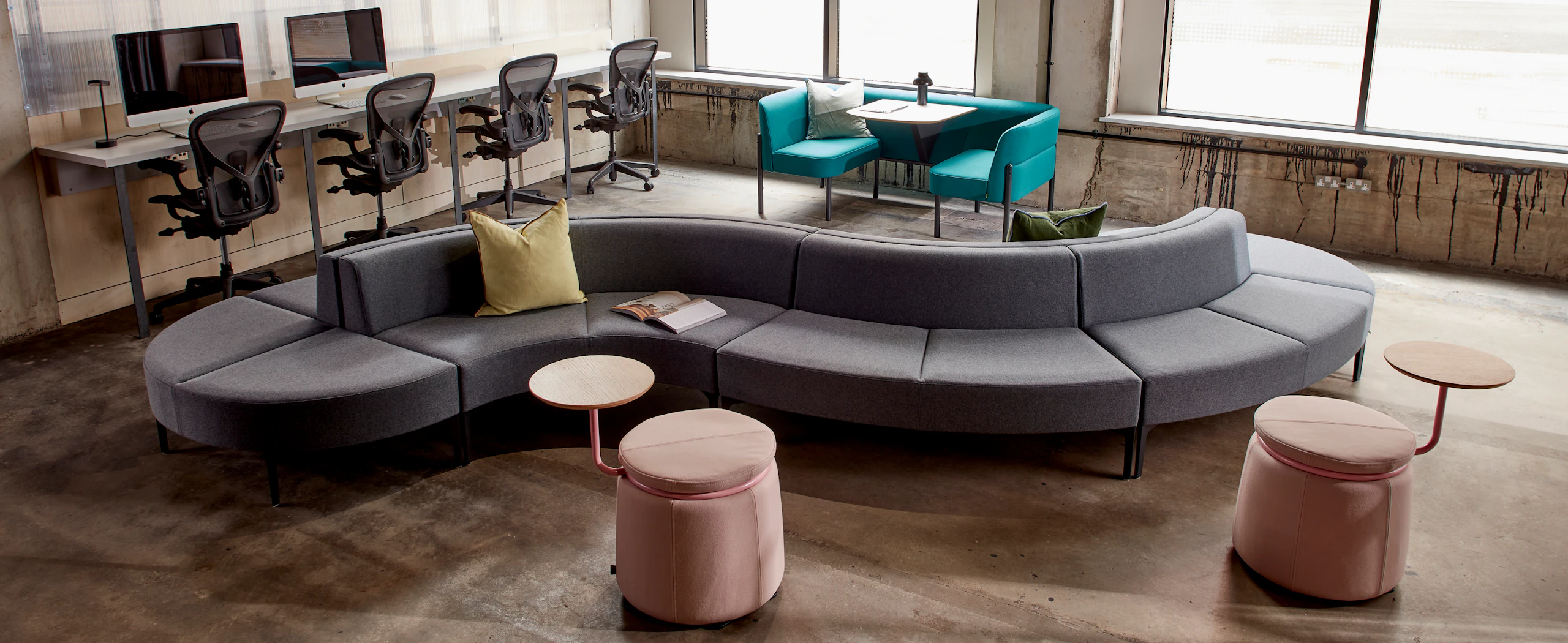 A wide angle of Synbol Modular Seating with 2 pink Lasso stools, a blue Hue Booth and 4 Aeron chairs.
