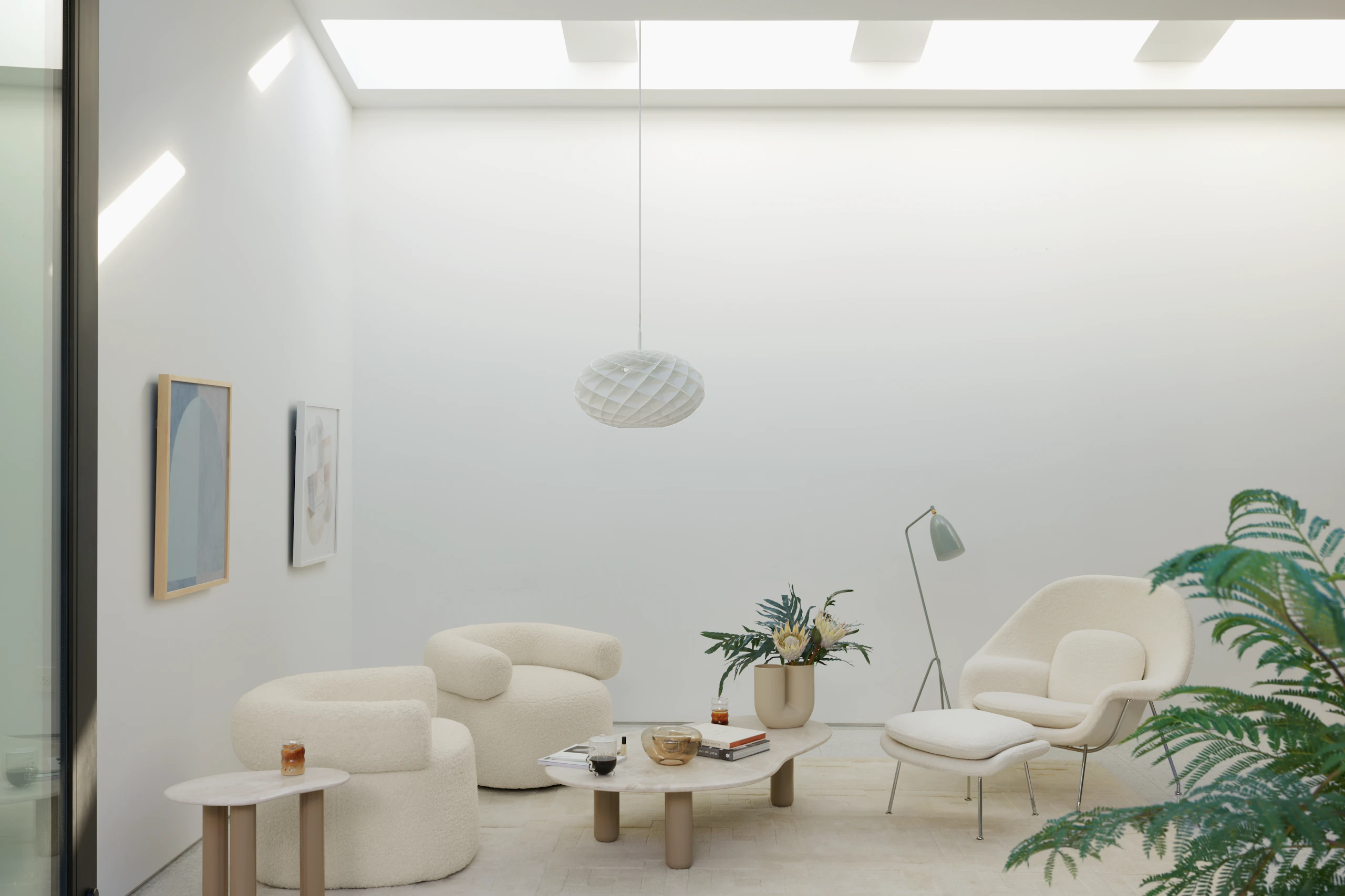 Seating area with Huggy chairs, Womb Chair, and Womb ottoman around a Piscina coffee table.
