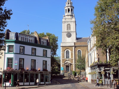 A bustling street lined with breathtaking architecture and vibrant businesses in the Clerkenwell neighborhood in London