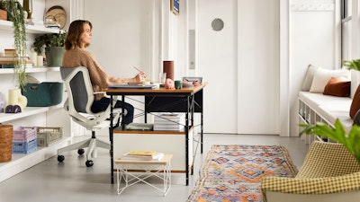 A professional working from home, using a Cosm Chair and an Eames Desk Unit.