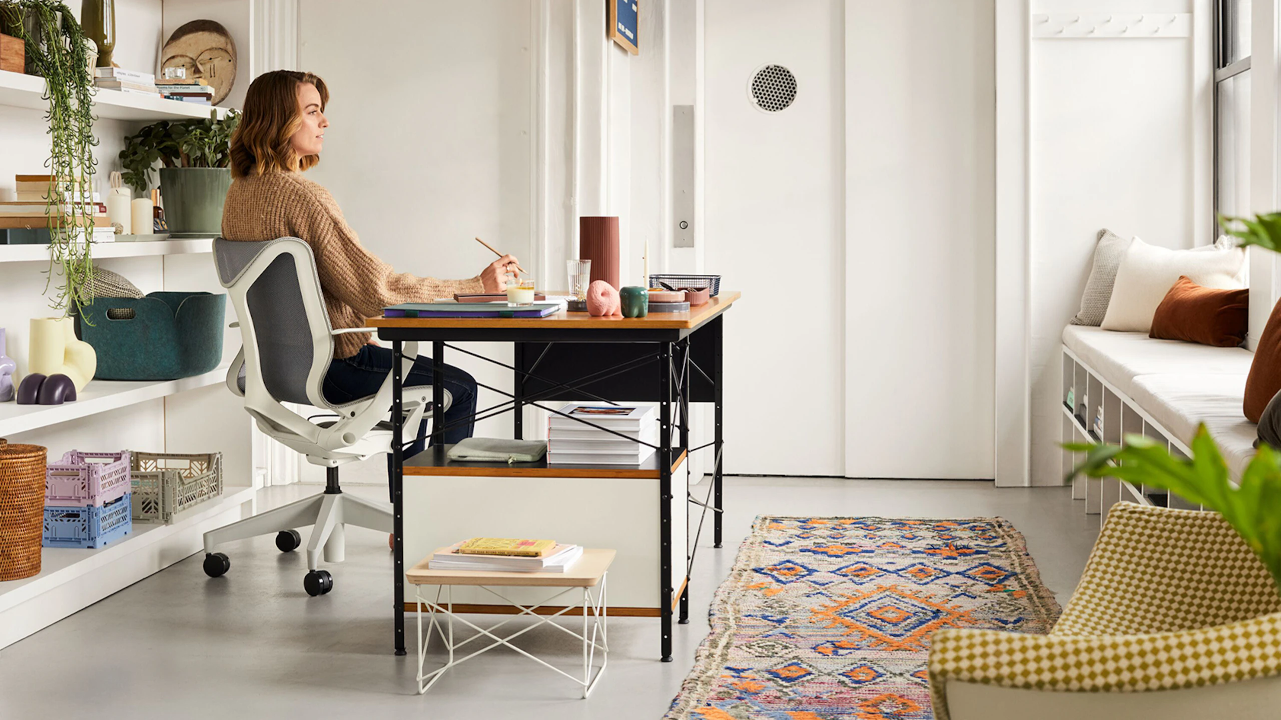 A professional working from home, using a Cosm Chair and an Eames Desk Unit.