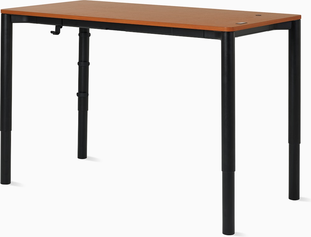 Angle view of a four leg height-adjustable table shown at standing height with a dark woodgrain surface and black base.