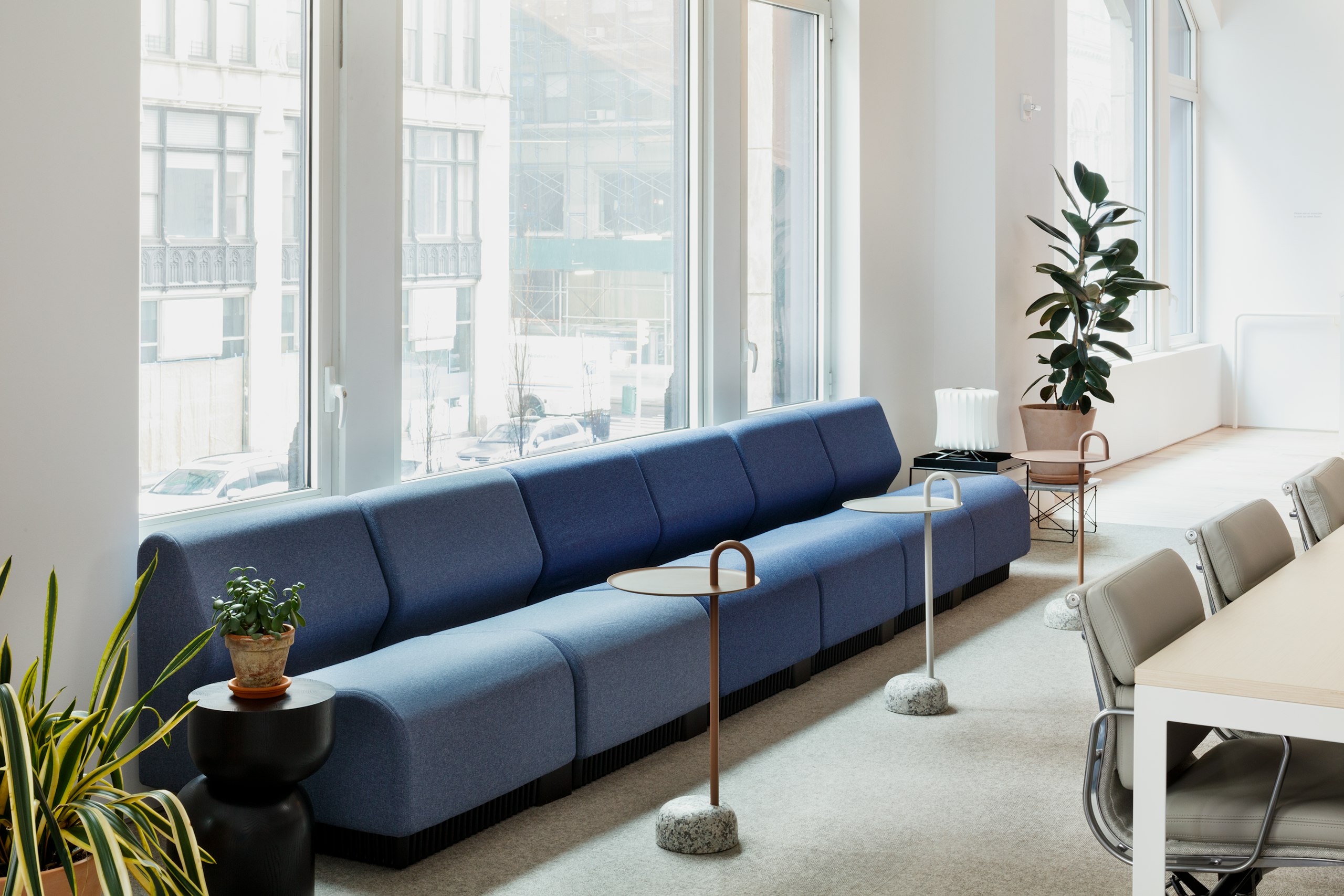 Angled view of multi blue tone Chadwick Modular Seating with black Hew Side Tables.