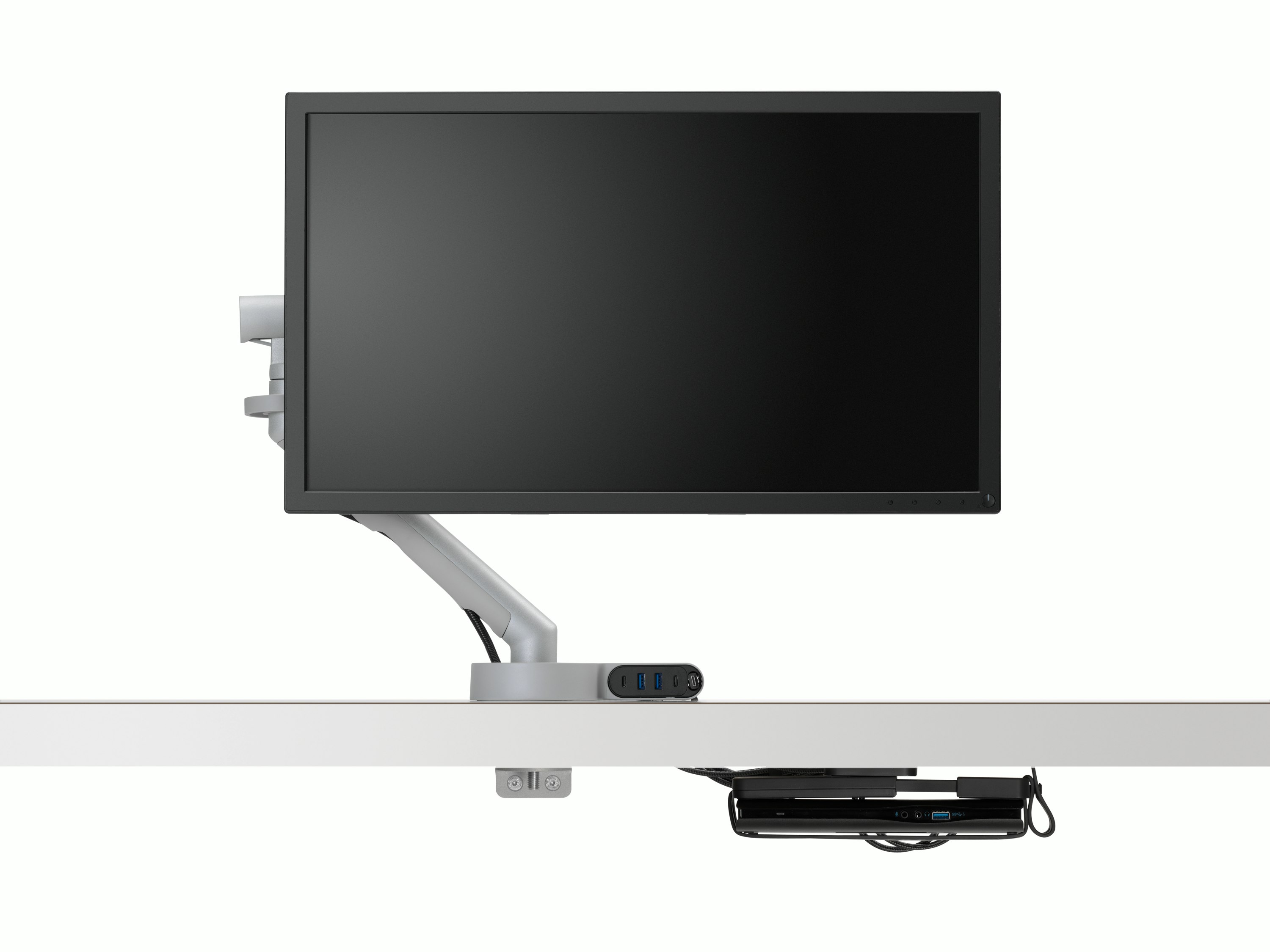 Front view of a screen and monitor arm with power cabling routed through Ondo Connectivity Module connected to the monitor arm and then through to Loop Micro Mount under the desk.