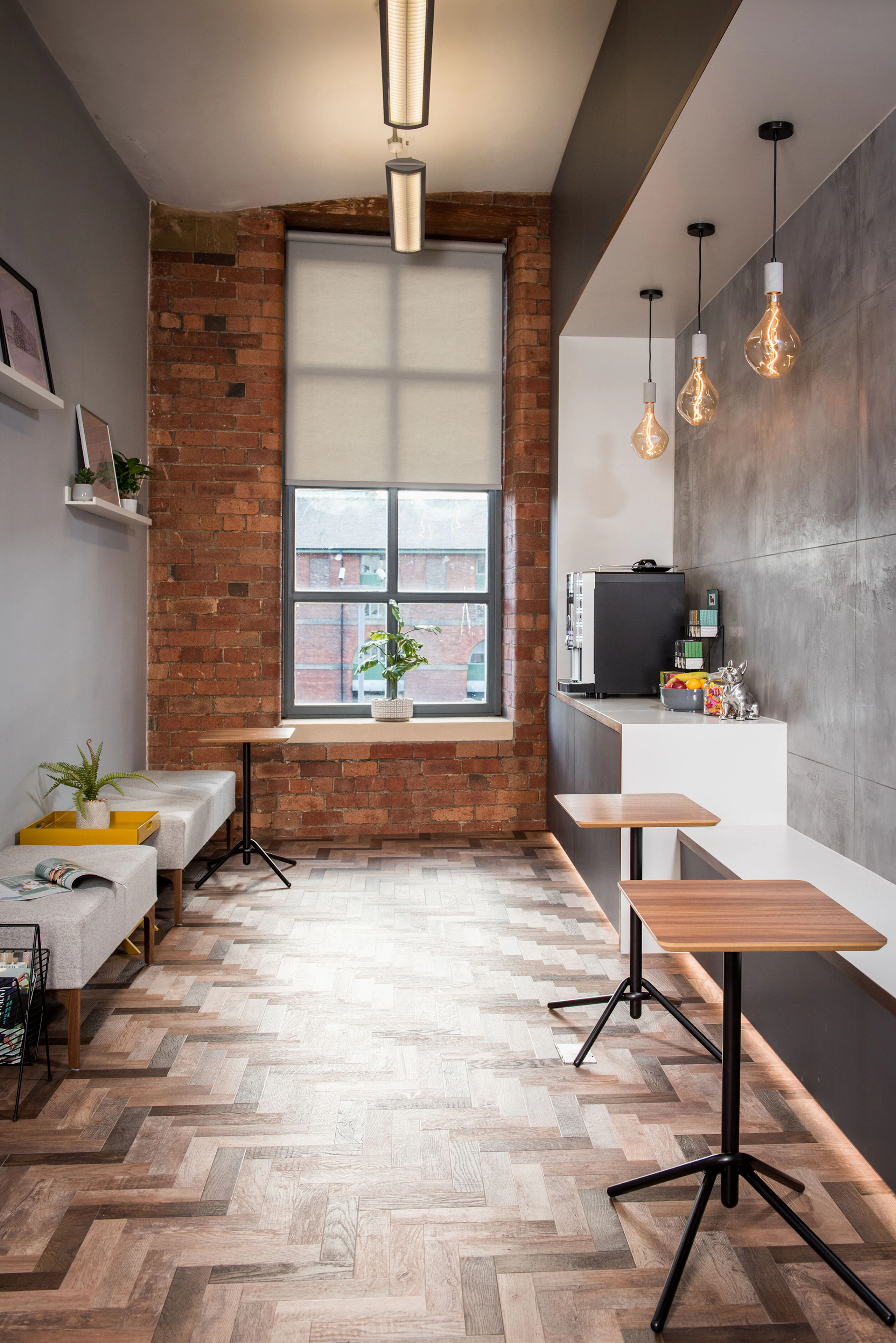 Three rectangular Knot Side Tables with wooden tops and black bases in an employee lounge along with two gray Hatch Benches.